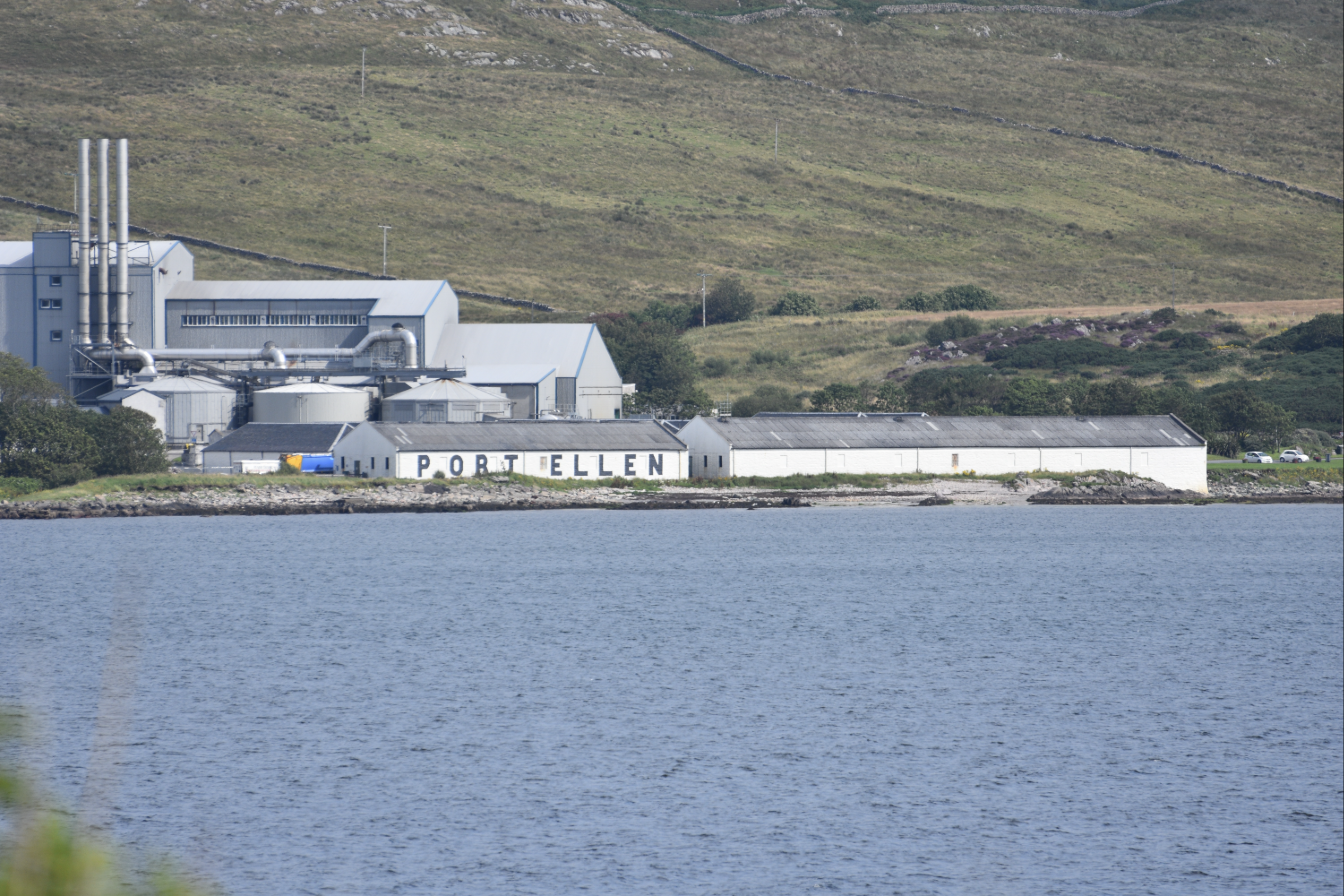 Port Ellen distillery, Islay, seen across the bay: the bonded warehouses still carry the distillery's name along the shore.