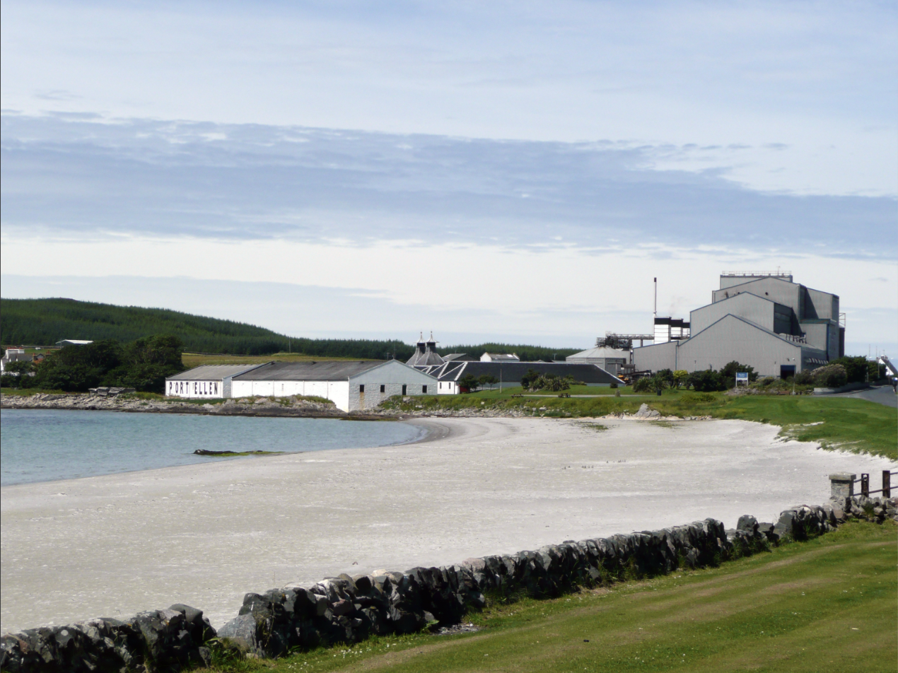 Port Ellen's shoreline warehouse and the maltings' pagoda-roofed kilns, seen from the beach. The maltings never stopped operating, during the distillery’s closure from 1983 to 2024.