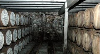 Inside Warehouse No. 1 at Laphroaig Distillery, Islay: a genuine dunnage warehouse, casks stacked exactly the two-to-three-high the text describes.